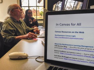 Richard Lepine works on his Canvas site while Les James helps another instructor with her Canvas site.